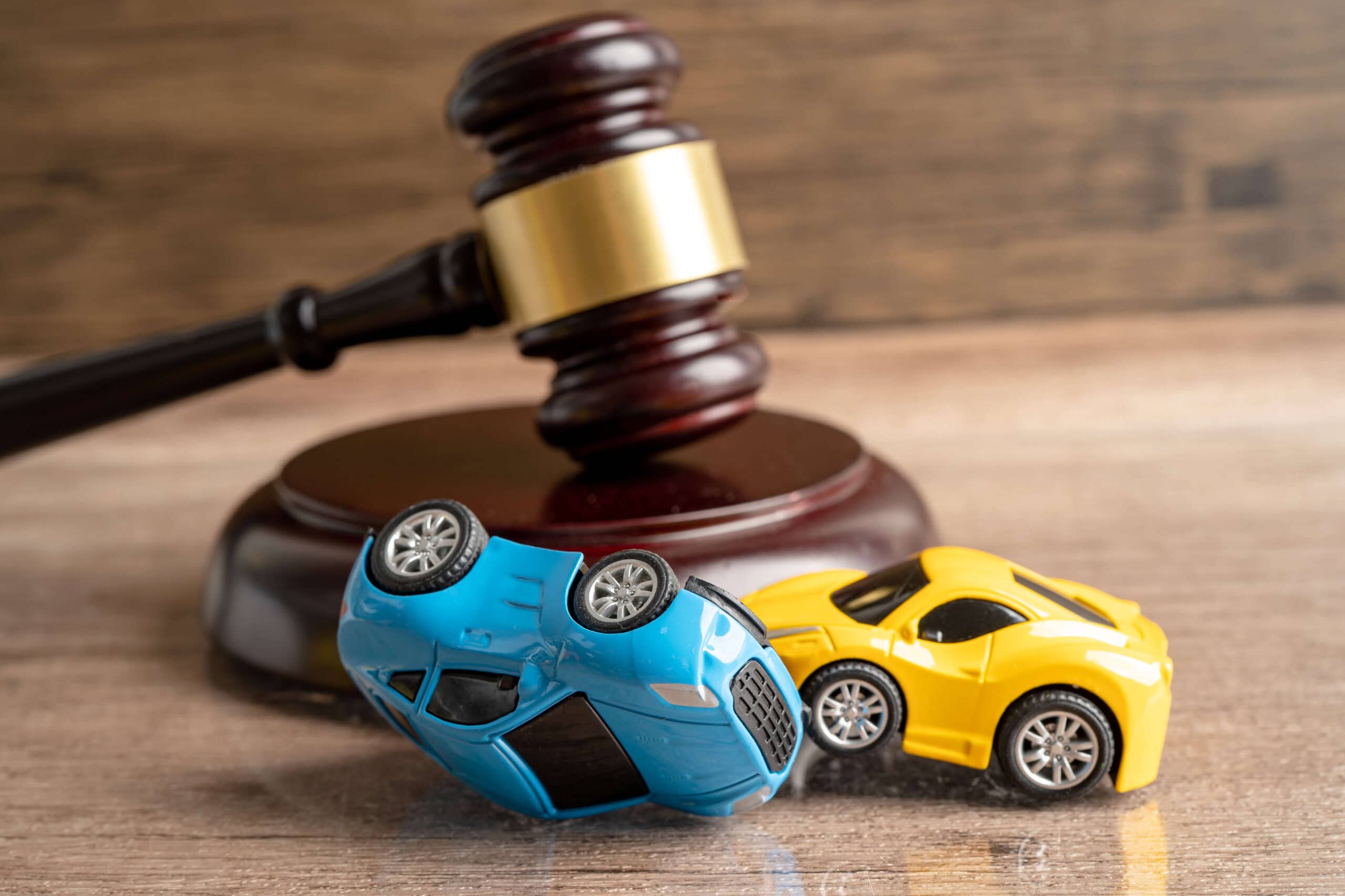 Marteau d’un juge avec deux jouets de voiture